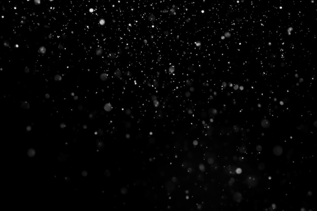 Fallender Schnee isoliert auf schwarzem Hintergrund