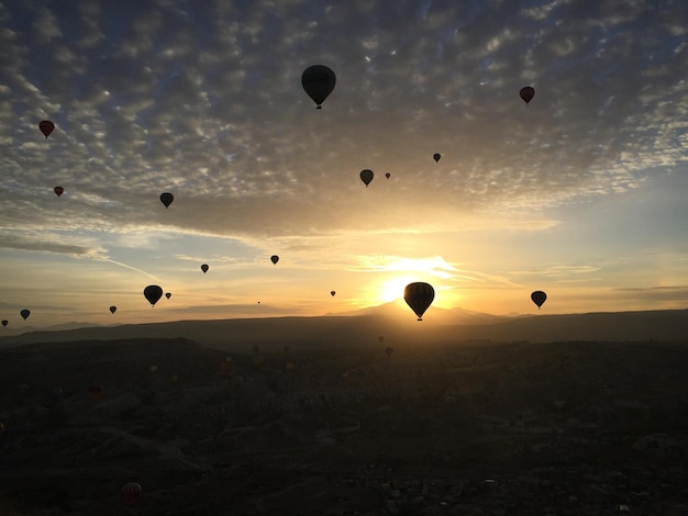 Fallschirme über der Silhouette der Landschaft beim Sonnenuntergang