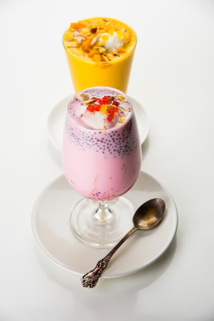 Falooda o Faluda es un postre indio popular: con sabor a fresa y mango que tiene helado, fideos, semillas de albahaca dulce y nueces, enfoque selectivo