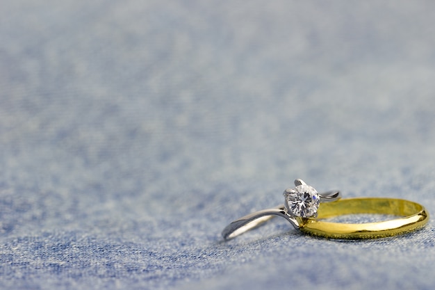 Foto falso anillo de diamantes y anillo de oro colocado en jean jecket