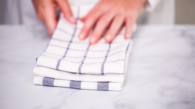 Faltende blau-weiß gemusterte Papierhandtücher auf Marmoroberfläche.