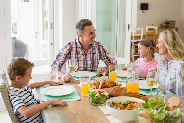 Família a comer na mesa de jantar em casa