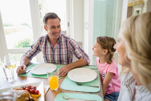 Família a comer na mesa de jantar em casa