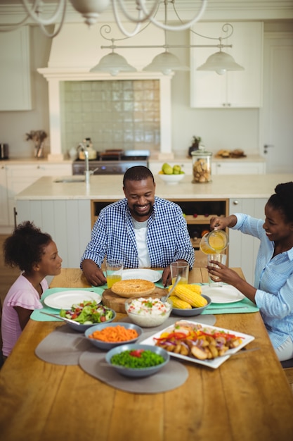 Família a comer na mesa de jantar em casa