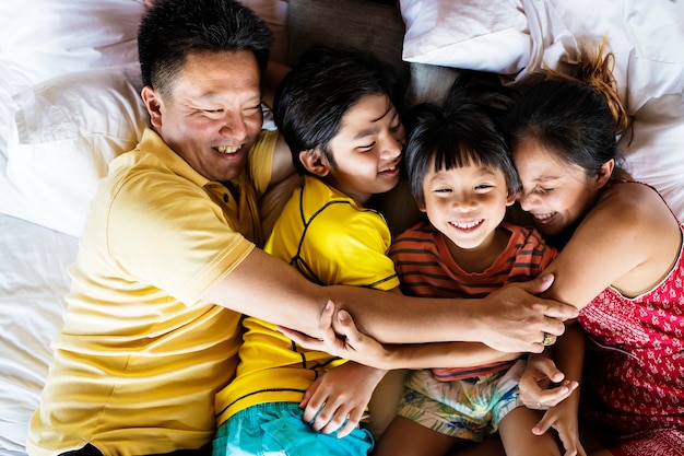 Familia abrazándose juntos en la cama