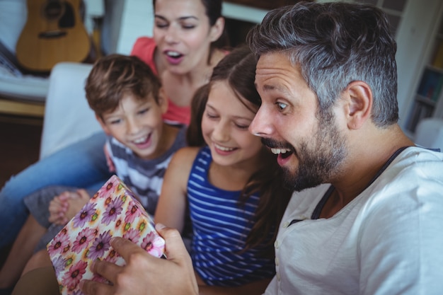 Foto familia abriendo el regalo sorpresa en la sala de estar