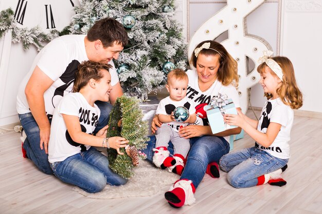 Família abrindo presentes de natal em casa juntos.