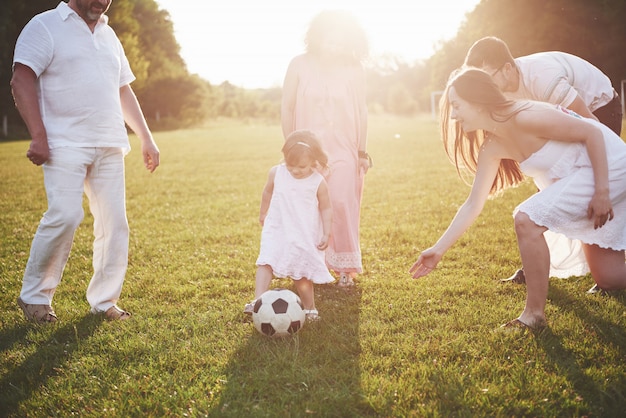 Foto familia activa alegre divirtiéndose en el campo en día de verano.