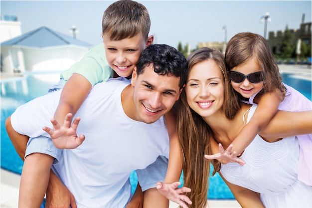 Família adorável feliz perto da piscina