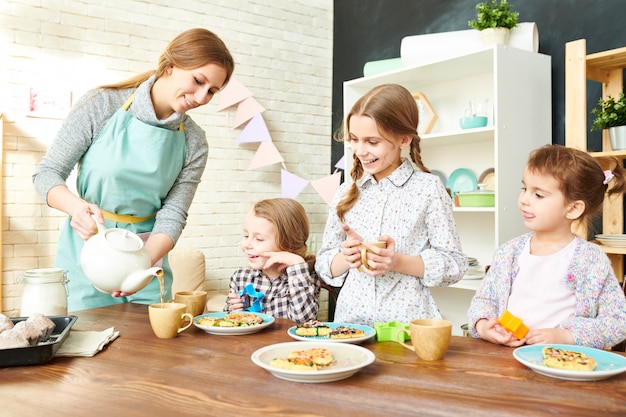 Família adorável que tem o tea party