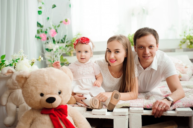 Família adorável, sorrindo e rindo, posando para a câmera e se abraçando