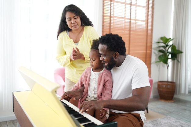 Familia africana feliz divirtiéndose en casa Amor familiar Padres y niños pequeños en el interior