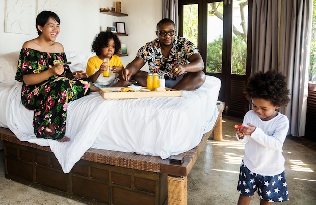 Família africana tomando café da manhã na cama