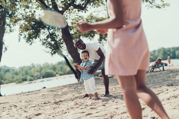 Família afro-americana está descansando na praia