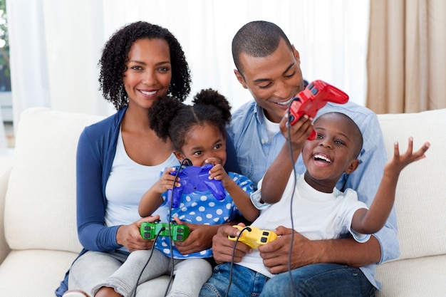 Família afro-americana feliz jogando videogame