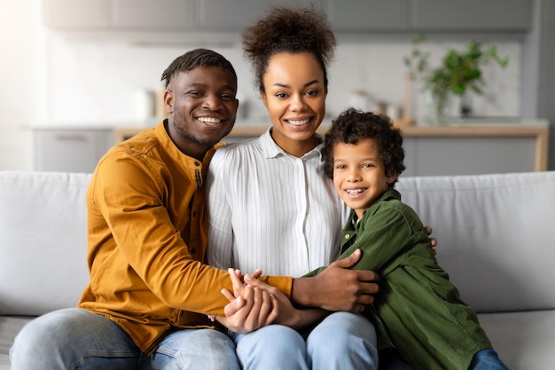 Família afro-americana feliz pais e filho menino sorrindo em casa