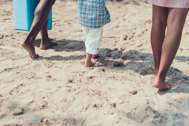 Família afro-americana na praia de areia do rio