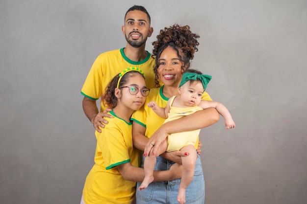 Foto família afro reunida com roupas brasileiras jogando pelo país