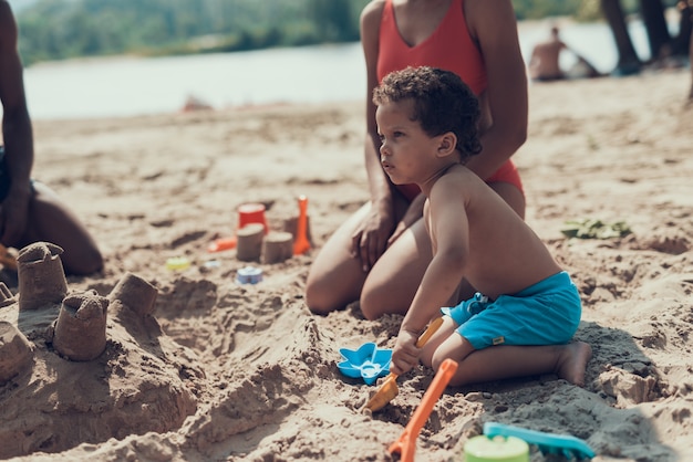 Familia afroamericana descansa en la playa de arena