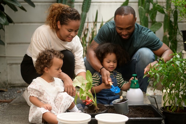 Familia afroamericana feliz disfrutando de la jardinería en casa