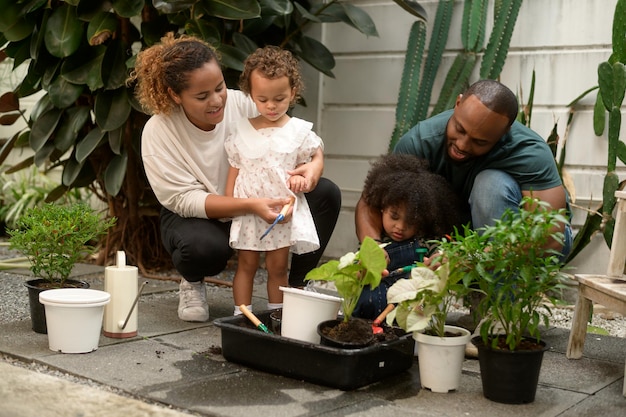 Familia afroamericana feliz disfrutando de la jardinería en casa