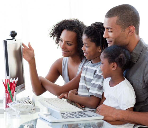 Familia afroamericana que trabaja con una computadora en casa