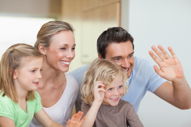 Familia agitando sus manos en la cocina