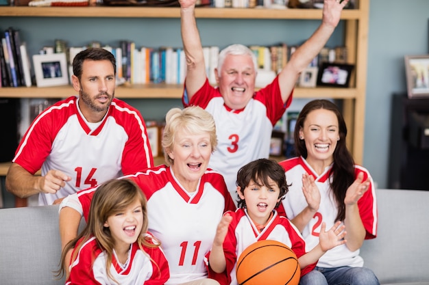 Familia alegre con abuelos viendo partido de baloncesto