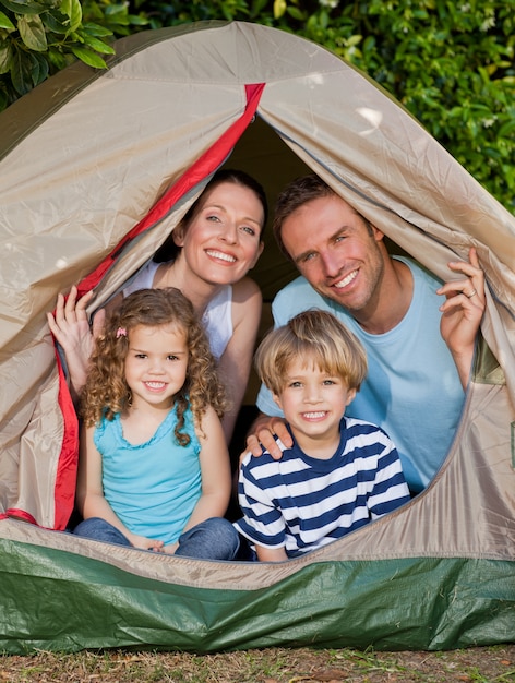 Família alegre acampando no jardim