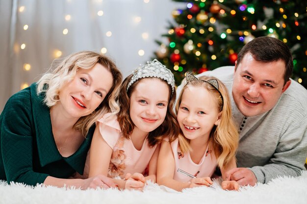 Una familia alegre ante el árbol de navidad.