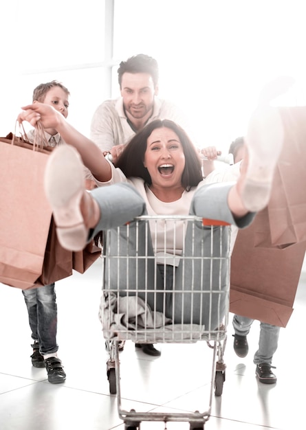 Foto familia alegre va de compras en un hipermercado