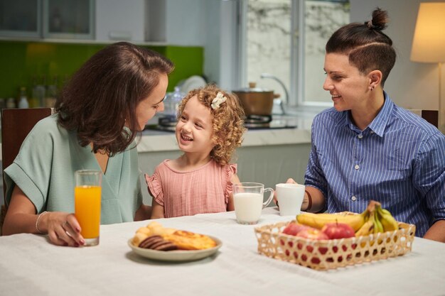 Foto família alegre de três comendo