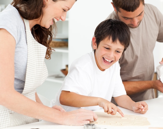 Familia alegre divirtiéndose mientras prepara galletas juntos