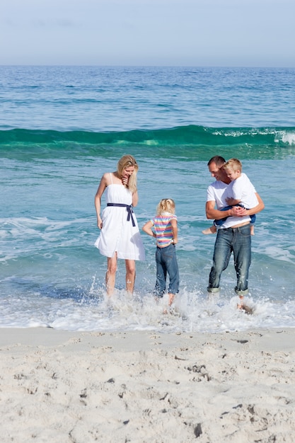 Familia alegre divirtiéndose en la playa
