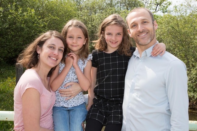 Foto família alegre em uma mãe de pai de parque e suas duas filhas adoráveis