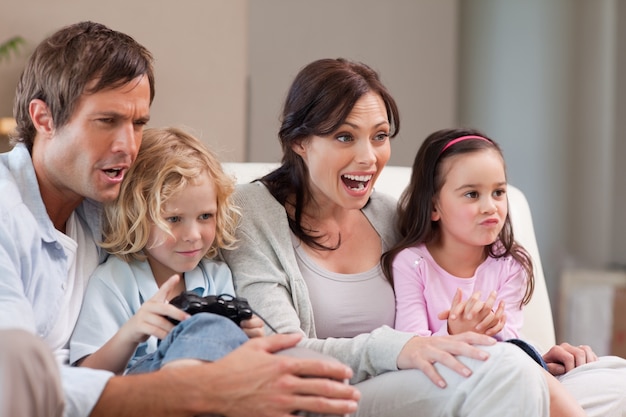 Familia alegre jugando videojuegos juntos