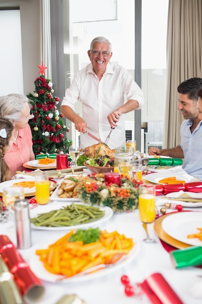Família alegre na mesa de jantar para o jantar de Natal