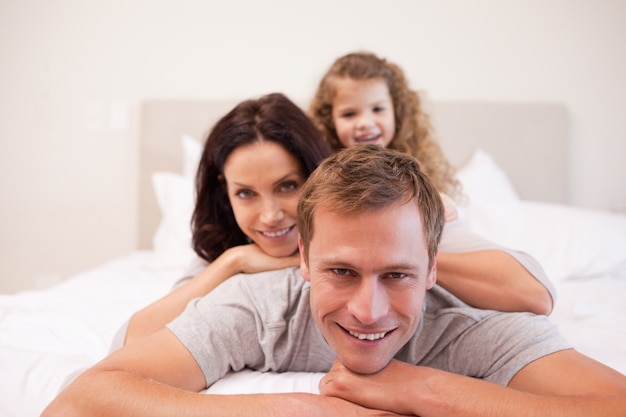 Familia alegre pasando un buen rato en el dormitorio