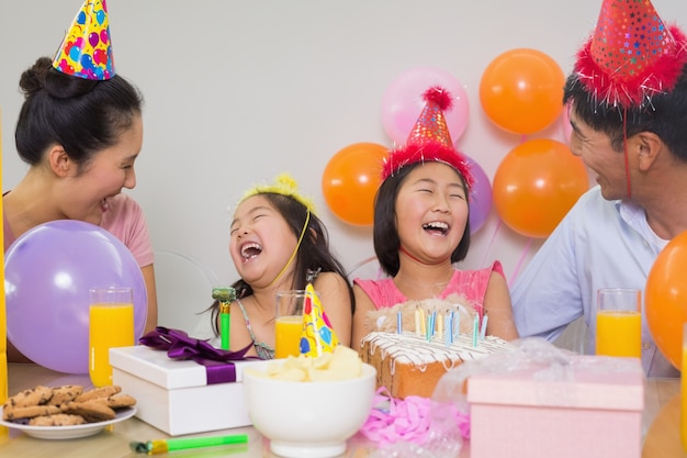 Familia alegre con pastel y regalos en una fiesta de cumpleaños