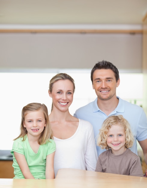 Familia alegre de pie en la cocina juntos