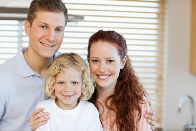 Familia alegre de pie en la cocina