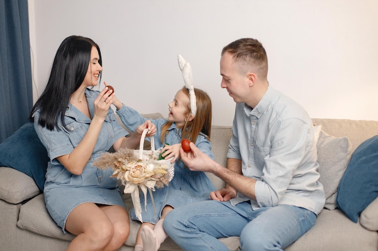 Foto família alegre reunida em um sofá na sala de estar se preparando para os ovos de páscoa juntos