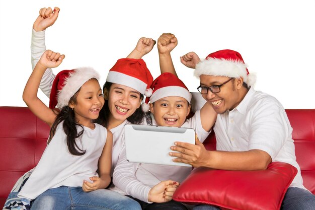 Familia alegre usando una tableta en Navidad