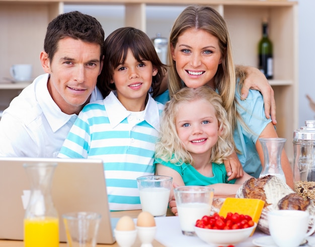 Familia alegre, usar la computadora portátil, durante, el, desayuno