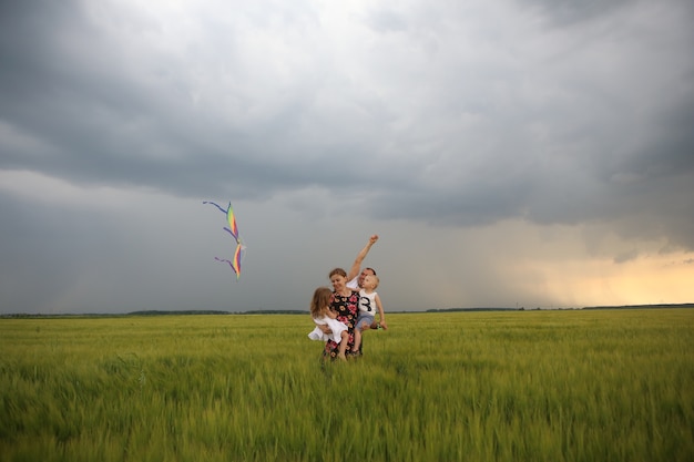 Familia alegría volando cometa campo viento niños