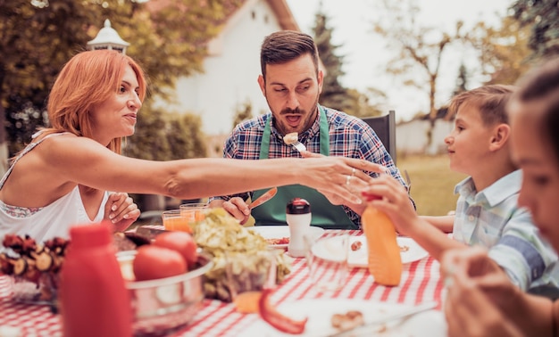 Família almoçando fora no jardim