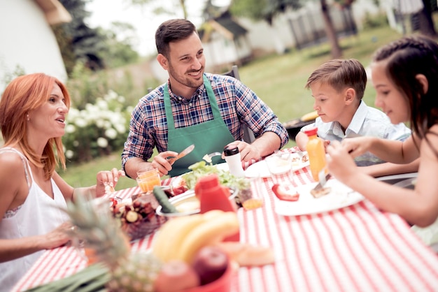 Família almoçando no jardim no verão