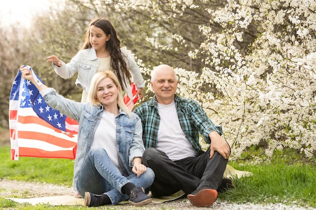 familia americana con bandera de Estados Unidos al aire libre.