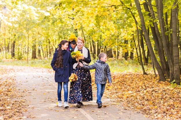 Família amigável caminhando juntos no parque no outono