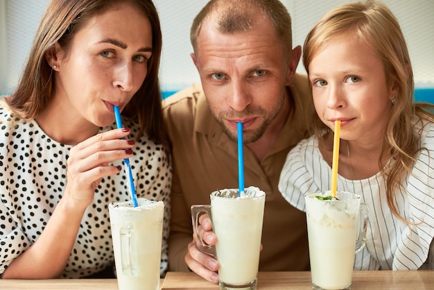 Familia amistosa con batidos en la cafetería